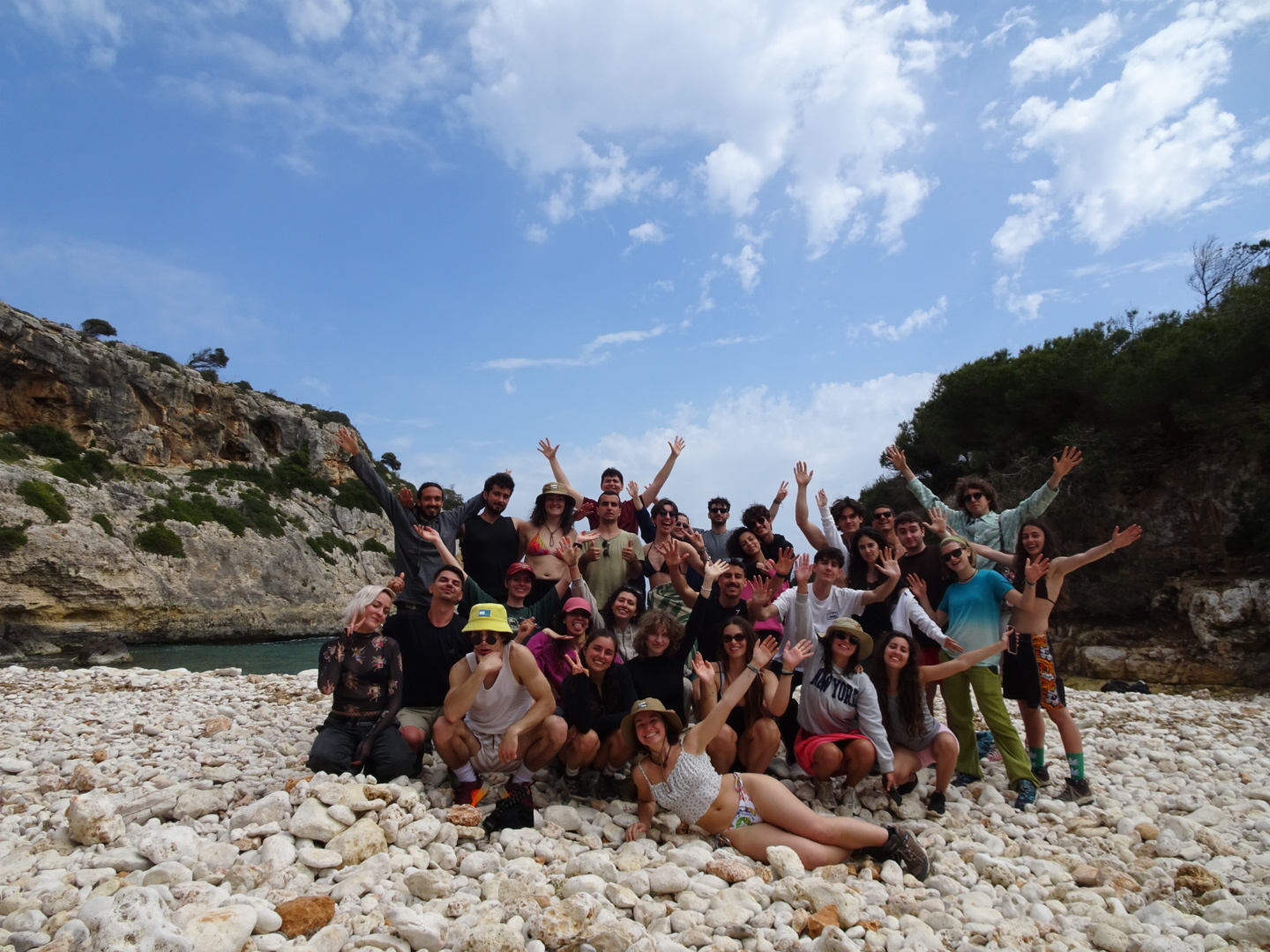Todo el grupo de Earth Explorers con los brazos en alto en una cala de Mallorca